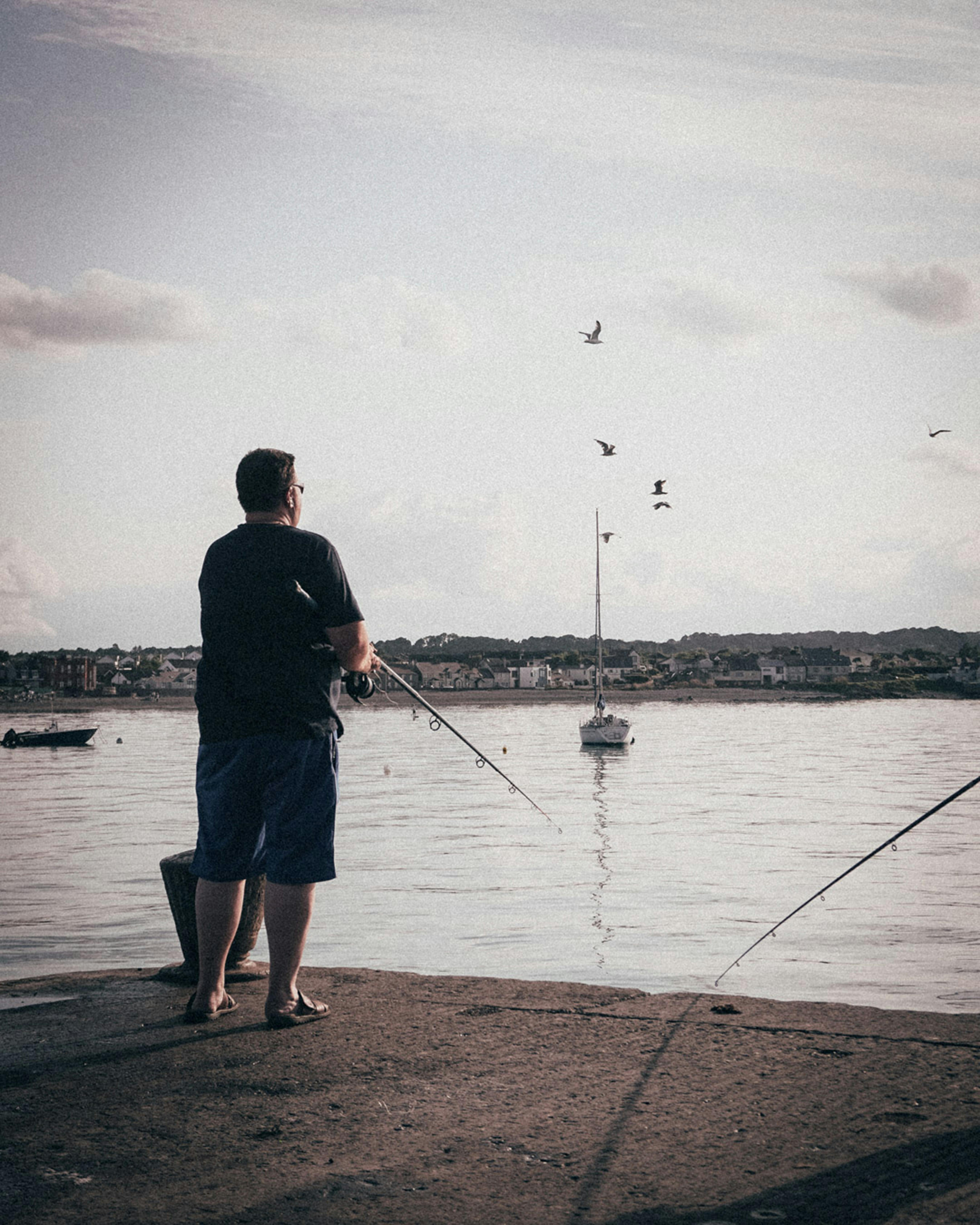 A family fishing for mackerel from a stone pier on the west coast of Ireland with the Atlantic in the background